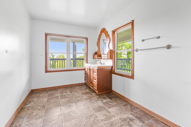 2466 655th Ave, Albia, IA 52531 - bathroom featuring vanity, baseboards, and stone finish floors