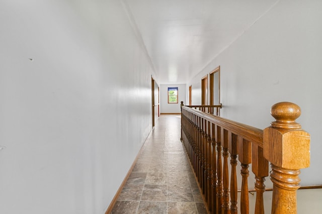 2466 655th Ave, Albia, IA 52531 - hallway featuring baseboards, an upstairs landing, and stone finish flooring