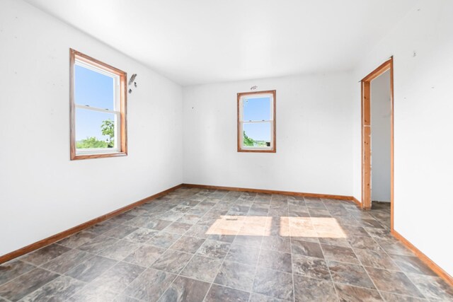 2466 655th Ave, Albia, IA 52531 - empty room featuring healthy amount of natural light, baseboards, and stone finish floors
