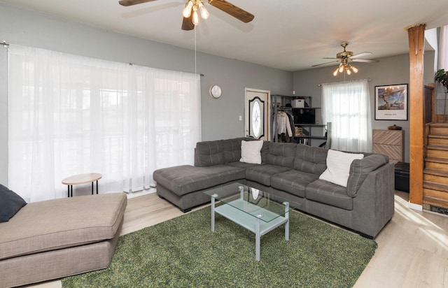 living room featuring light hardwood / wood-style flooring and ceiling fan