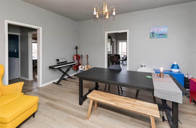 dining space with wood-type flooring and an inviting chandelier