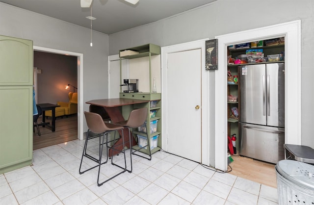 kitchen featuring ceiling fan, stainless steel refrigerator, and green cabinetry