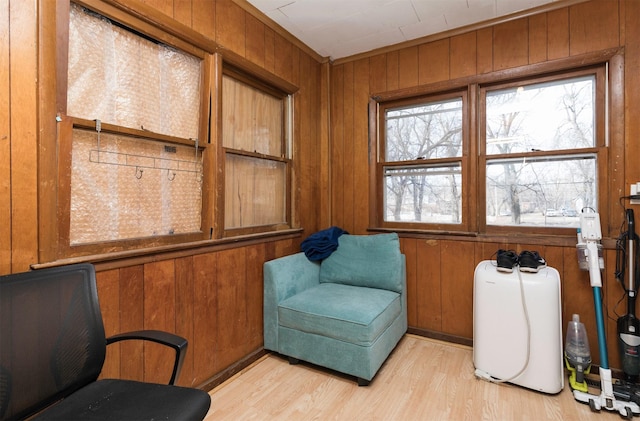 sitting room featuring light wood-type flooring and wood walls