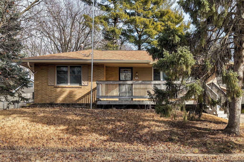 ranch-style house with a deck and brick siding