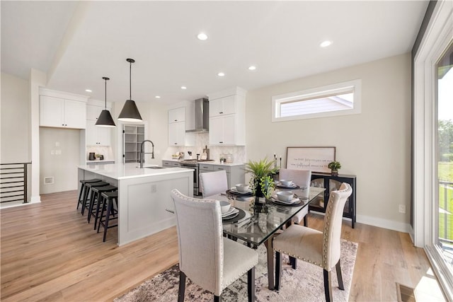 dining area with sink and light hardwood / wood-style floors