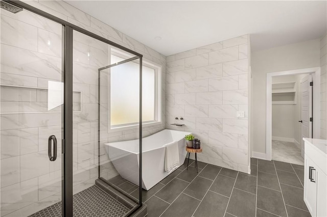 bathroom with tile patterned flooring, vanity, separate shower and tub, and tile walls