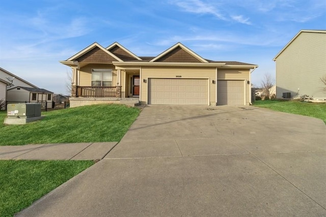 view of front of property with central AC, a garage, covered porch, and a front yard