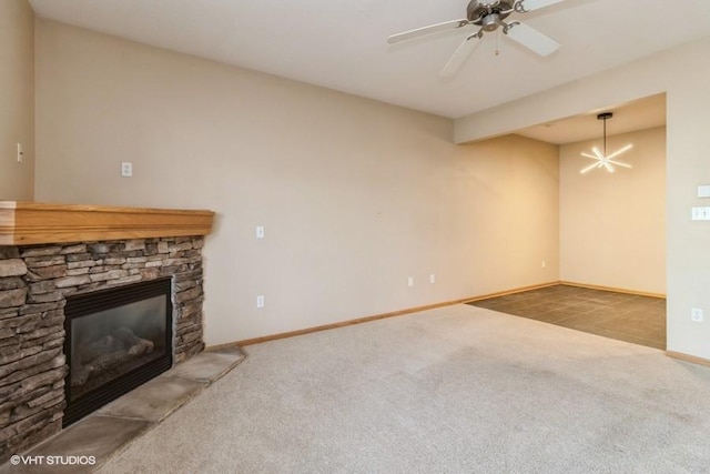 unfurnished living room featuring light carpet, a stone fireplace, and ceiling fan with notable chandelier