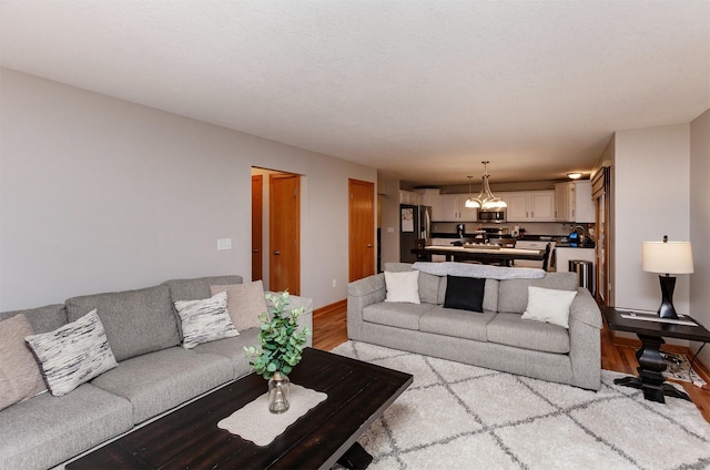 living room featuring an inviting chandelier and light hardwood / wood-style flooring