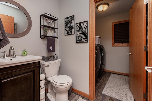 bathroom featuring vanity, wood-type flooring, toilet, and washing machine and clothes dryer