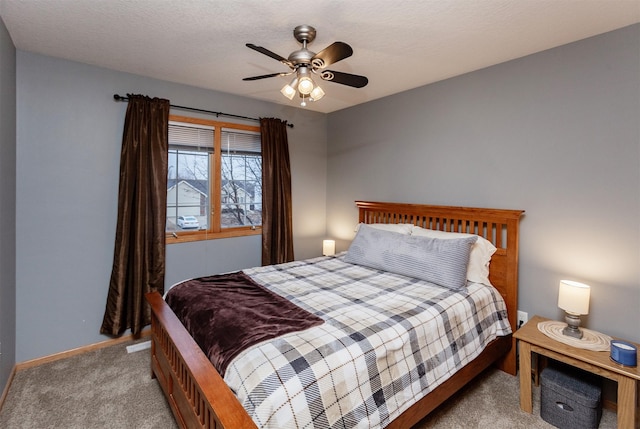 bedroom featuring light carpet, a textured ceiling, and ceiling fan