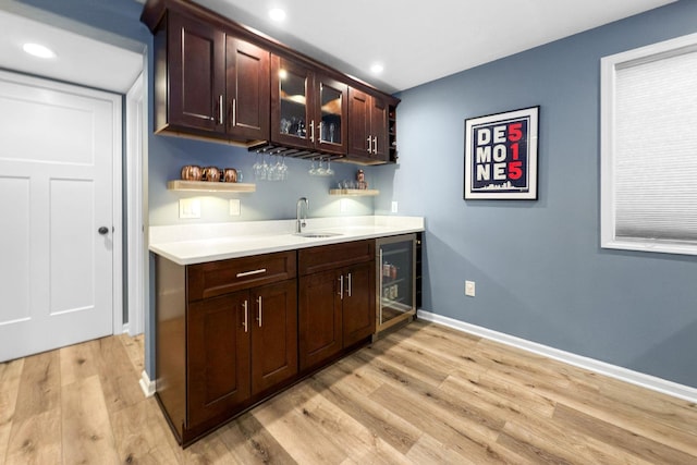 bar with sink, wine cooler, and light hardwood / wood-style floors