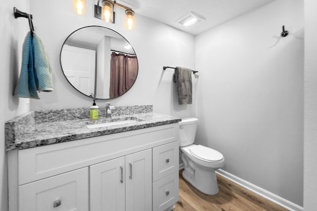 bathroom with vanity, wood-type flooring, and toilet