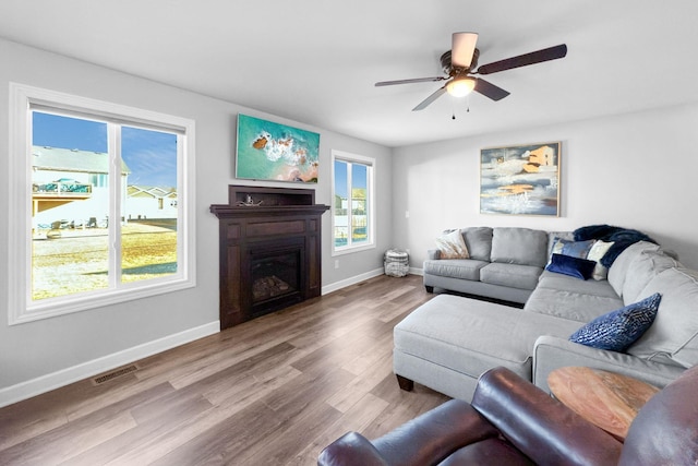 living room featuring wood-type flooring and ceiling fan