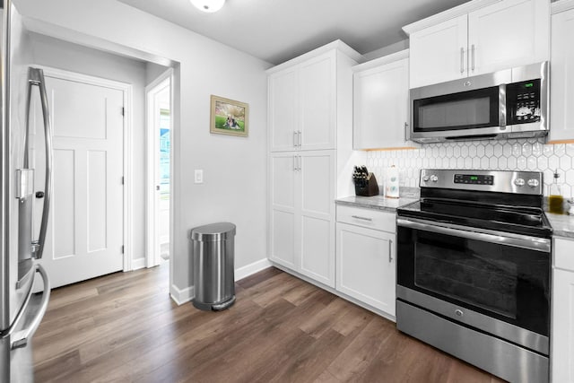 kitchen with appliances with stainless steel finishes, light stone countertops, and white cabinets