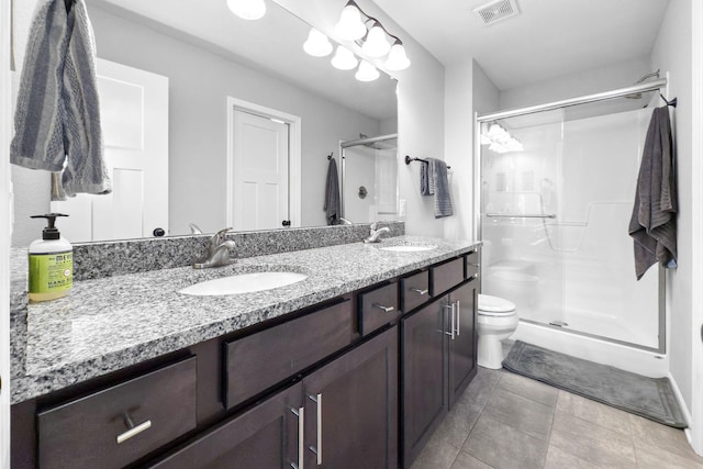 bathroom featuring vanity, toilet, and a shower with door