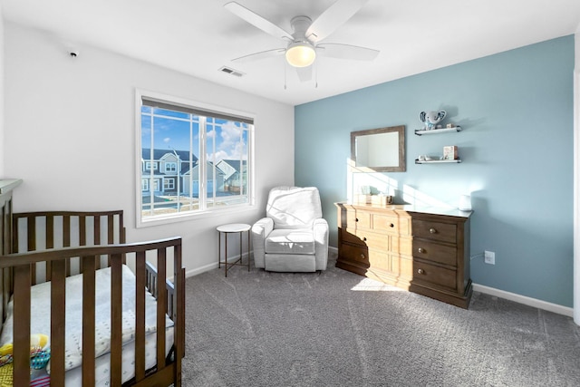 bedroom with a nursery area, ceiling fan, and carpet flooring