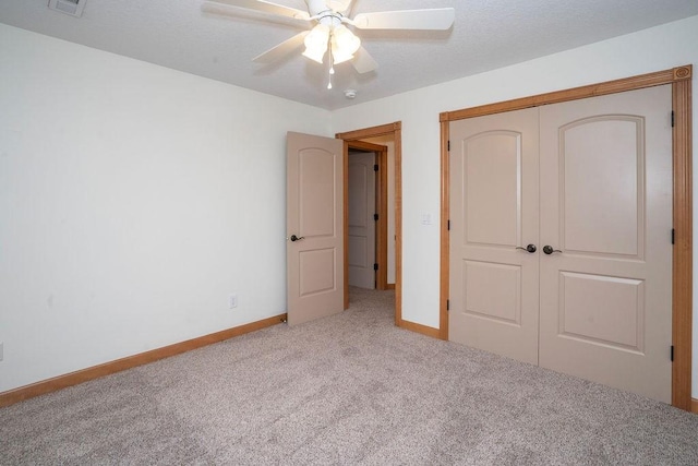 unfurnished bedroom with light colored carpet, ceiling fan, and a closet