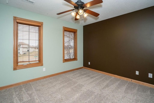 unfurnished room featuring ceiling fan, carpet, and a textured ceiling