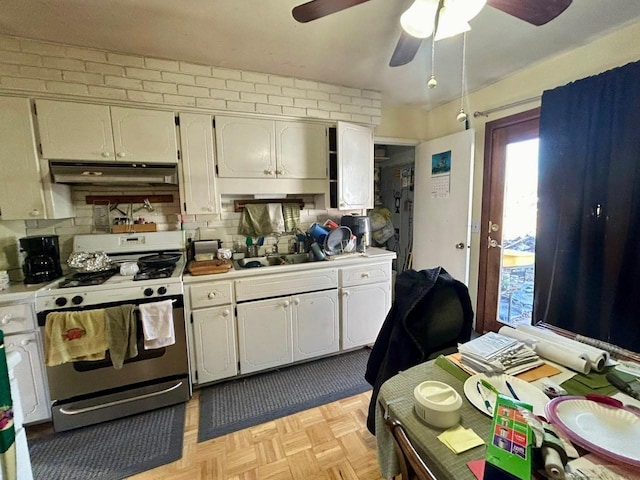 kitchen with sink, gas stove, ceiling fan, light parquet flooring, and decorative backsplash