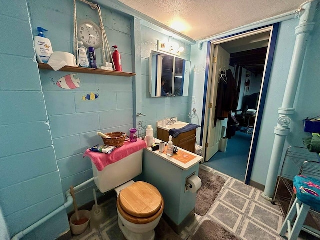 bathroom featuring toilet, sink, and a textured ceiling