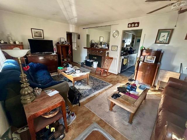 living room featuring ceiling fan and a fireplace