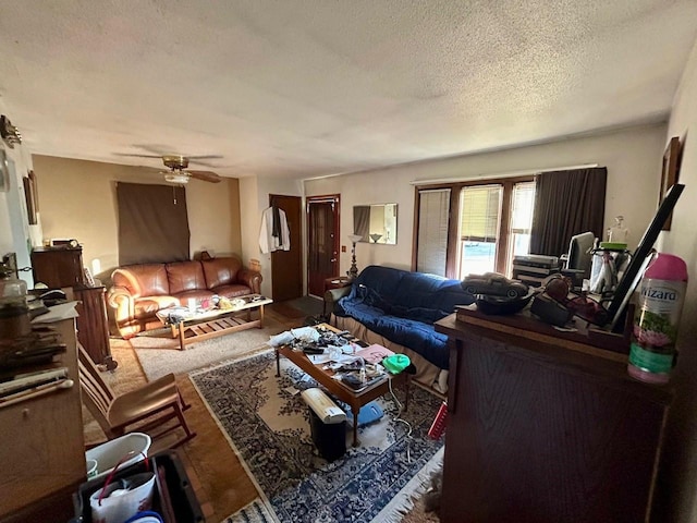 living room with ceiling fan and a textured ceiling