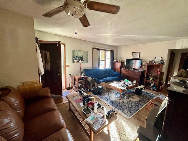 living room with a textured ceiling and ceiling fan