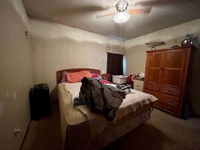 bedroom with ceiling fan, carpet floors, and a textured ceiling