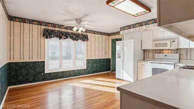 kitchen with white cabinetry, ceiling fan, white appliances, and light hardwood / wood-style floors