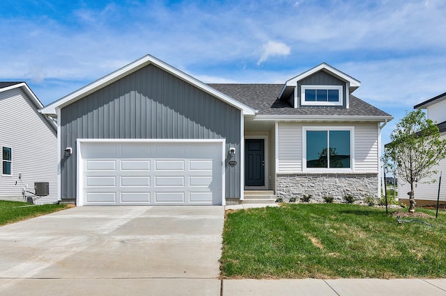 craftsman-style house featuring a garage, central AC unit, and a front lawn