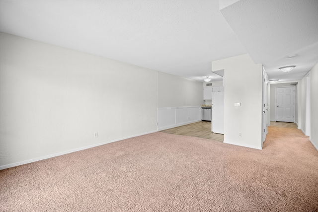 unfurnished living room featuring light colored carpet