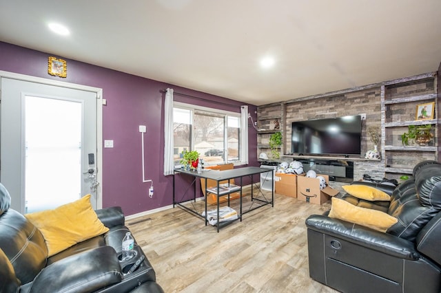 living room with built in shelves and light hardwood / wood-style floors