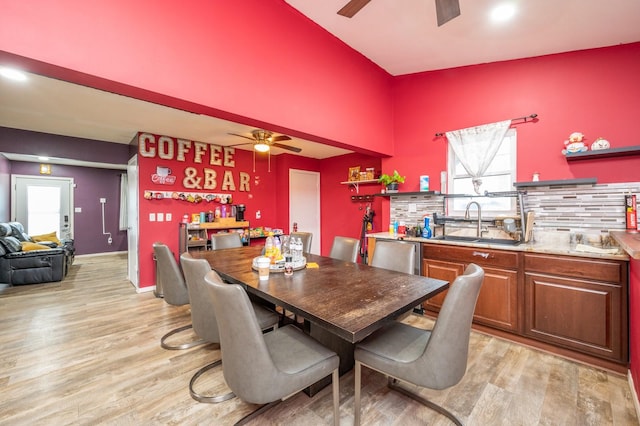 dining room with ceiling fan, sink, and light wood-type flooring