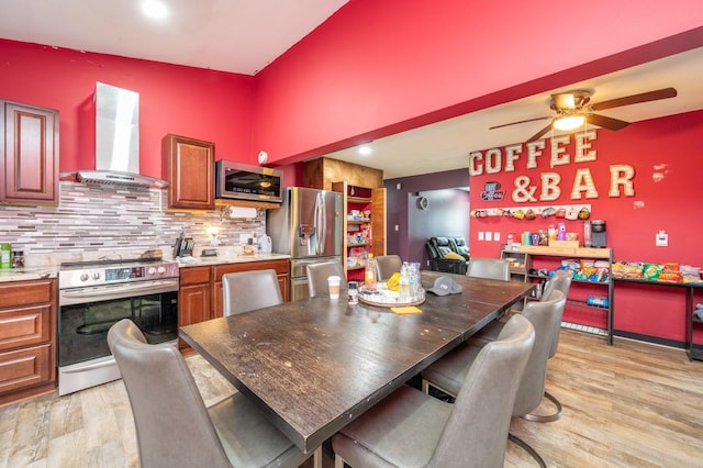 dining space with ceiling fan and light wood-type flooring