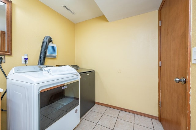 washroom featuring light tile patterned floors and washer and clothes dryer