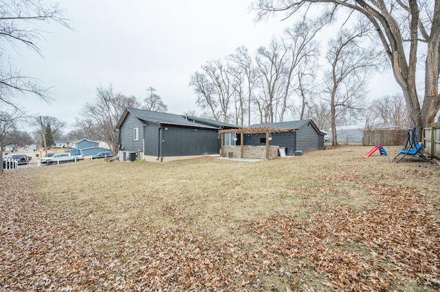 rear view of property featuring cooling unit and a lawn