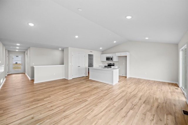 unfurnished living room with vaulted ceiling and light hardwood / wood-style floors