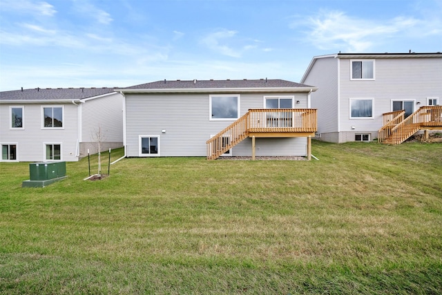 back of property featuring a wooden deck and a yard