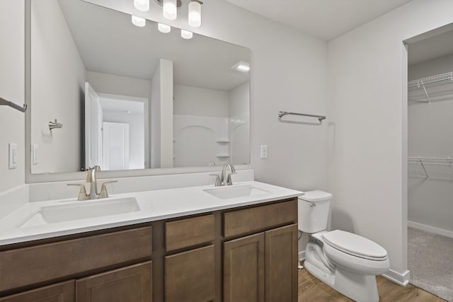1835 Tuscany Dr SE, Altoona, IA 50009 - bathroom featuring wood finished floors, double vanity, a spacious closet, and a shower
