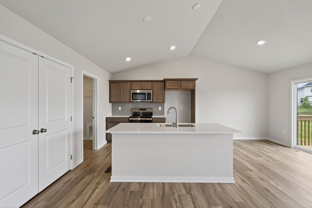 1835 Tuscany Dr SE, Altoona, IA 50009 - kitchen featuring stainless steel appliances, light wood finished floors, tasteful backsplash, light countertops, and lofted ceiling