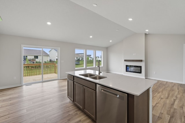 1835 Tuscany Dr SE, Altoona, IA 50009 - kitchen with stainless steel dishwasher, a glass covered fireplace, open floor plan, light wood-style flooring, and light countertops