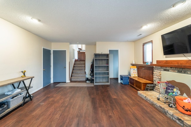 living room with dark wood-type flooring and a textured ceiling