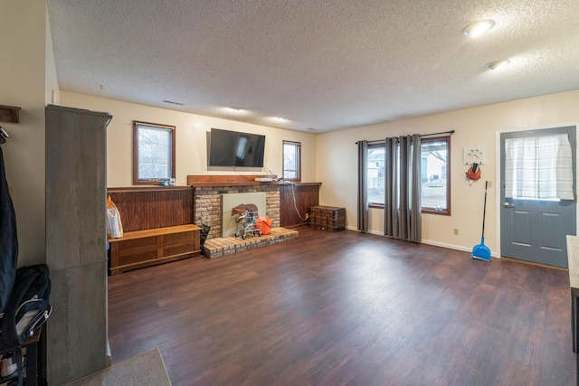 living room featuring dark hardwood / wood-style flooring, a fireplace, and a textured ceiling