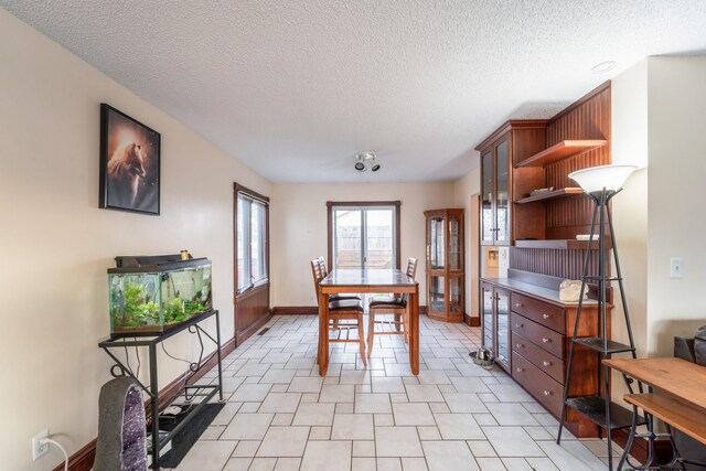 dining room featuring beverage cooler and a textured ceiling