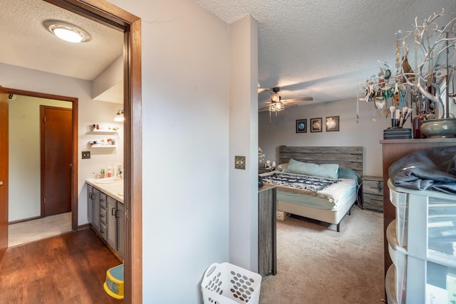 carpeted bedroom featuring a textured ceiling and ensuite bath