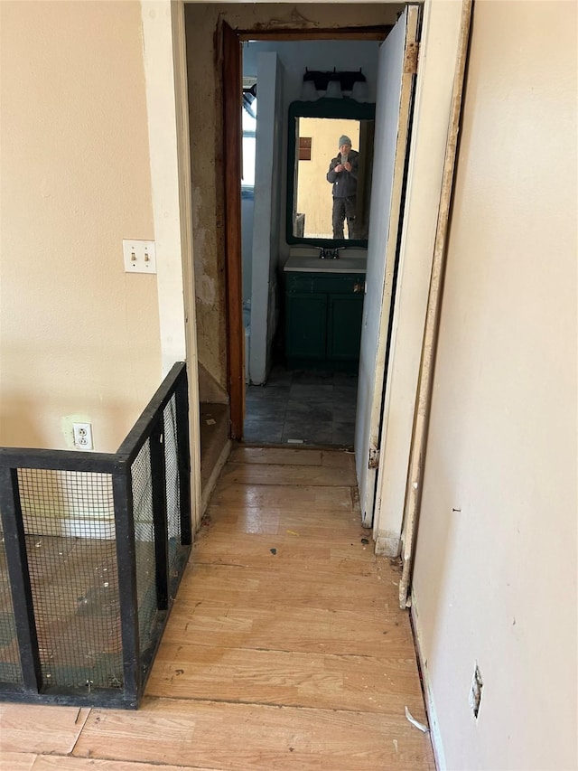 hallway with sink and light wood-type flooring