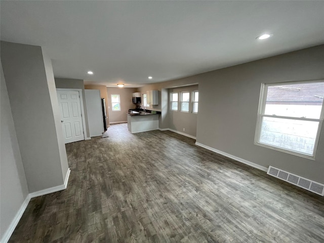 unfurnished living room with dark wood-type flooring