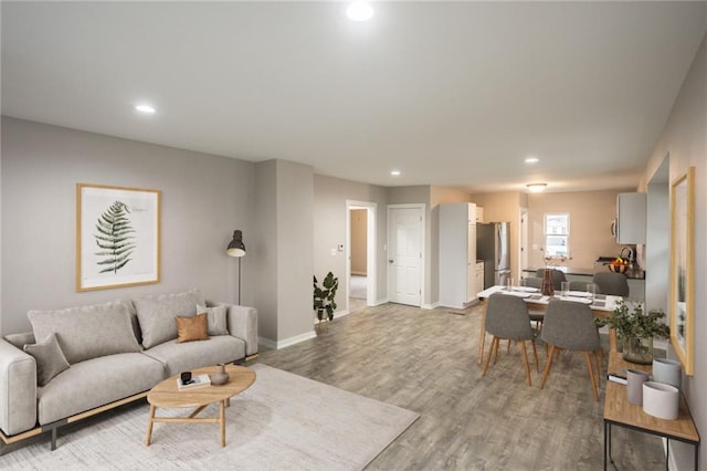 living room featuring recessed lighting, baseboards, and light wood-style floors