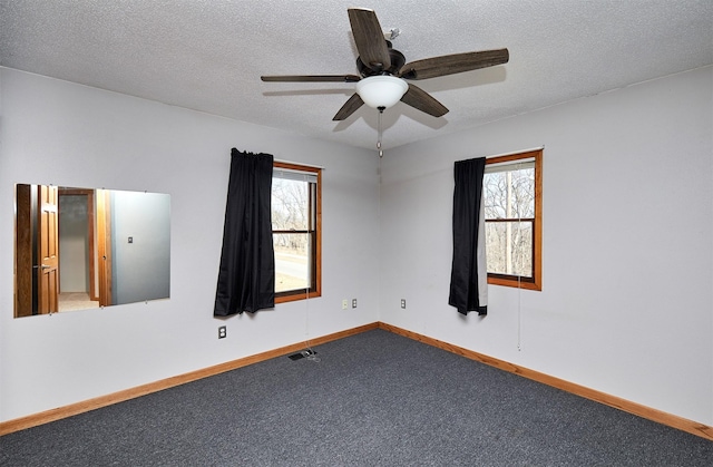 empty room featuring ceiling fan, a textured ceiling, and carpet flooring